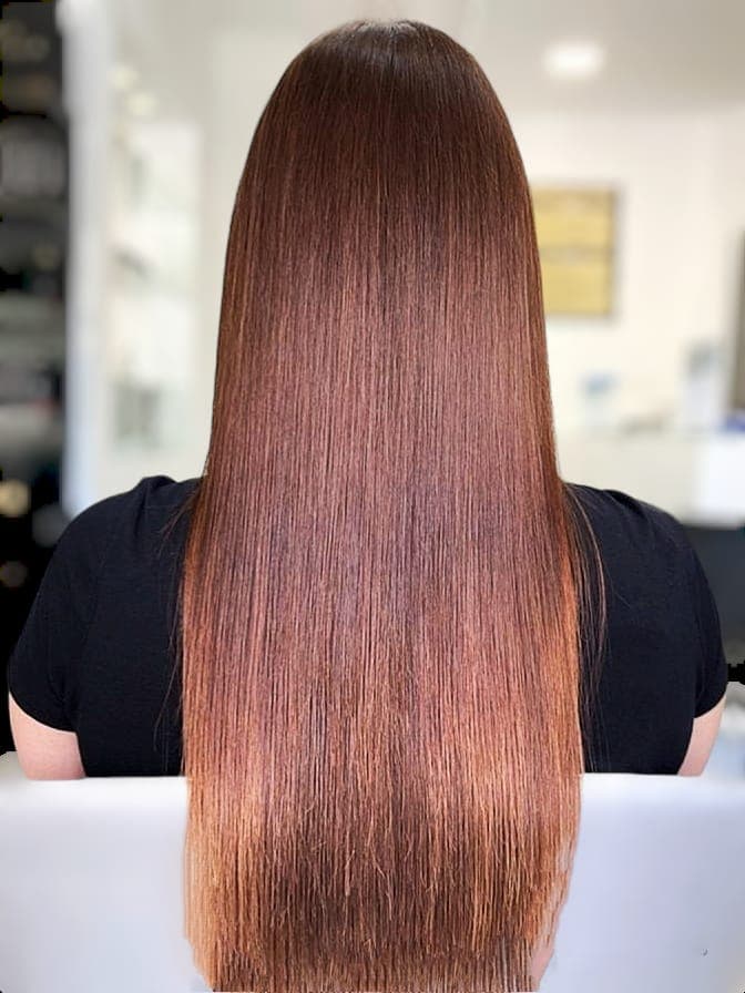 Piega liscia e lucida su capelli lunghi ramati