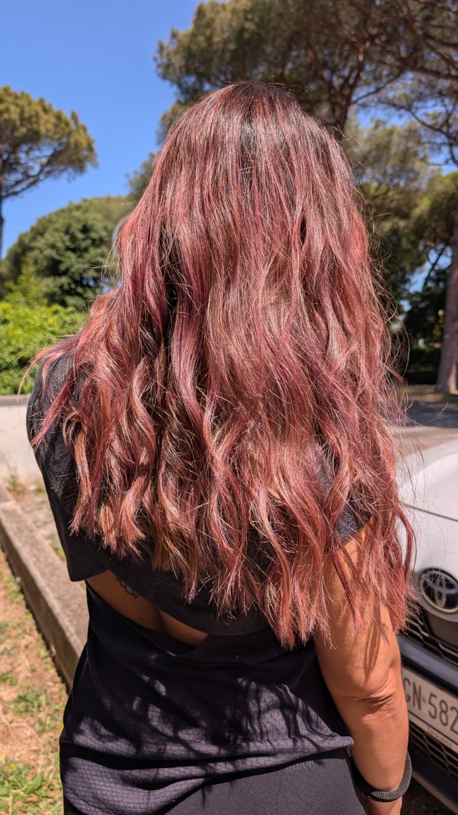 Capelli lunghi rosa ramato con onde, alla luce del sole