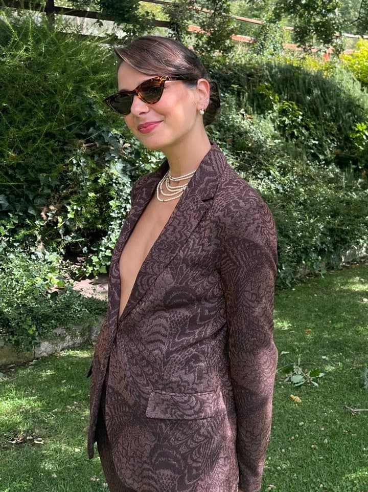 Cliente con un raccolto morbido e giacca elegante, in giardino
