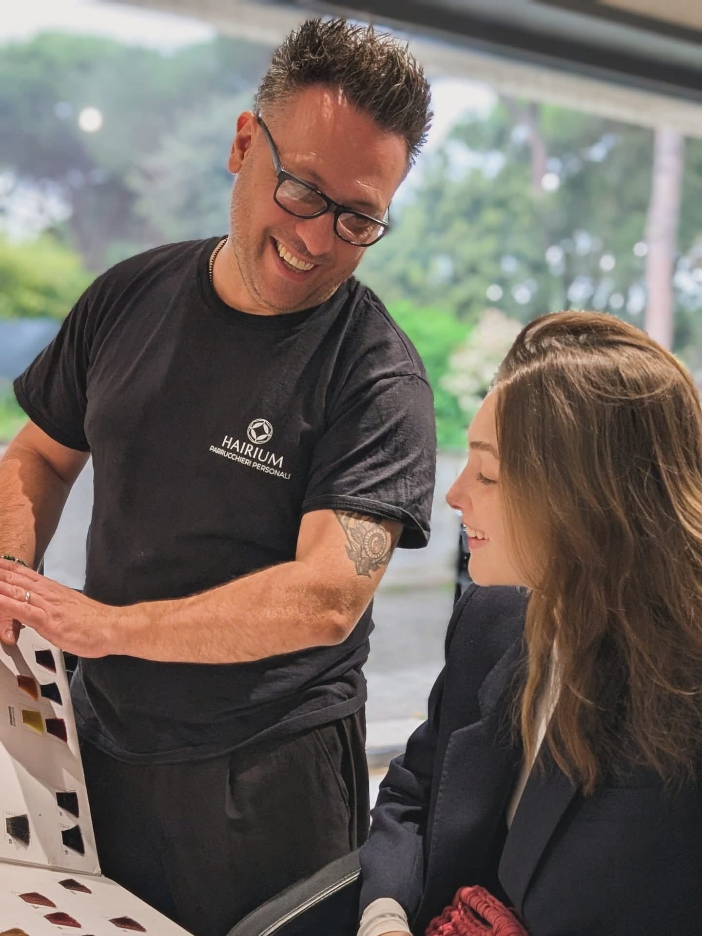 Consulenza colore: lo stylist sceglie la nuance con la cliente sulla cartella colori
