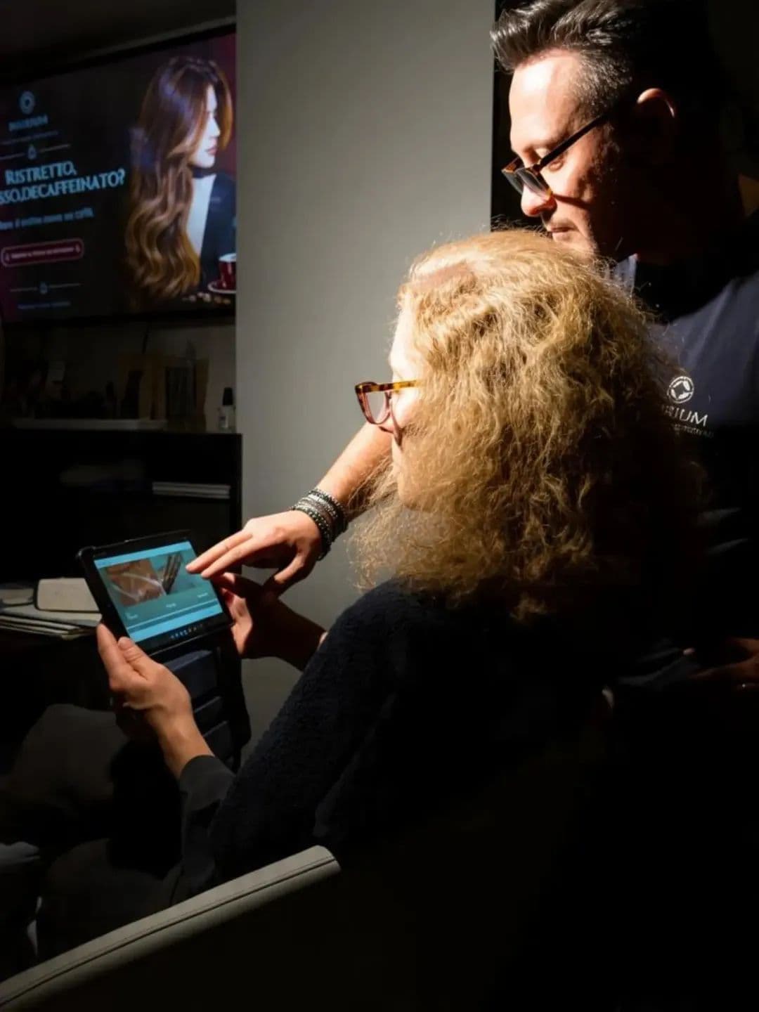 Alessandro Lerani mostra sul tablet il percorso consigliato a una cliente
